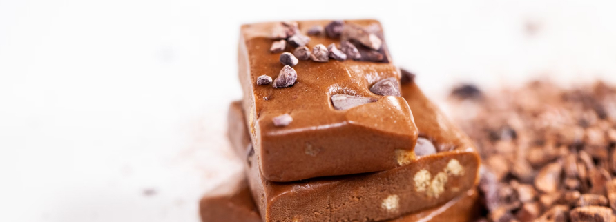 A stack of chocolate date brownies with large chunks of nuts visible on the surface